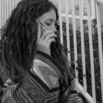 black and white image of woman in cardigan with phone to her ear.